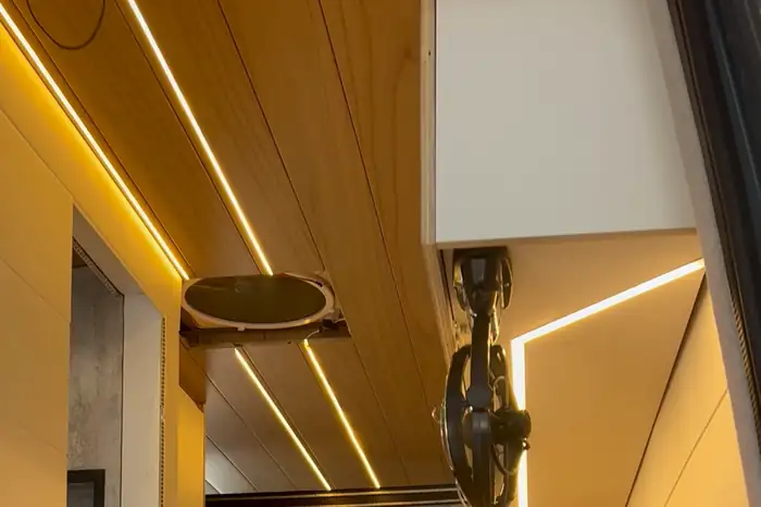 Warm LED strips recessed into the timber ceiling of a fitted campervan